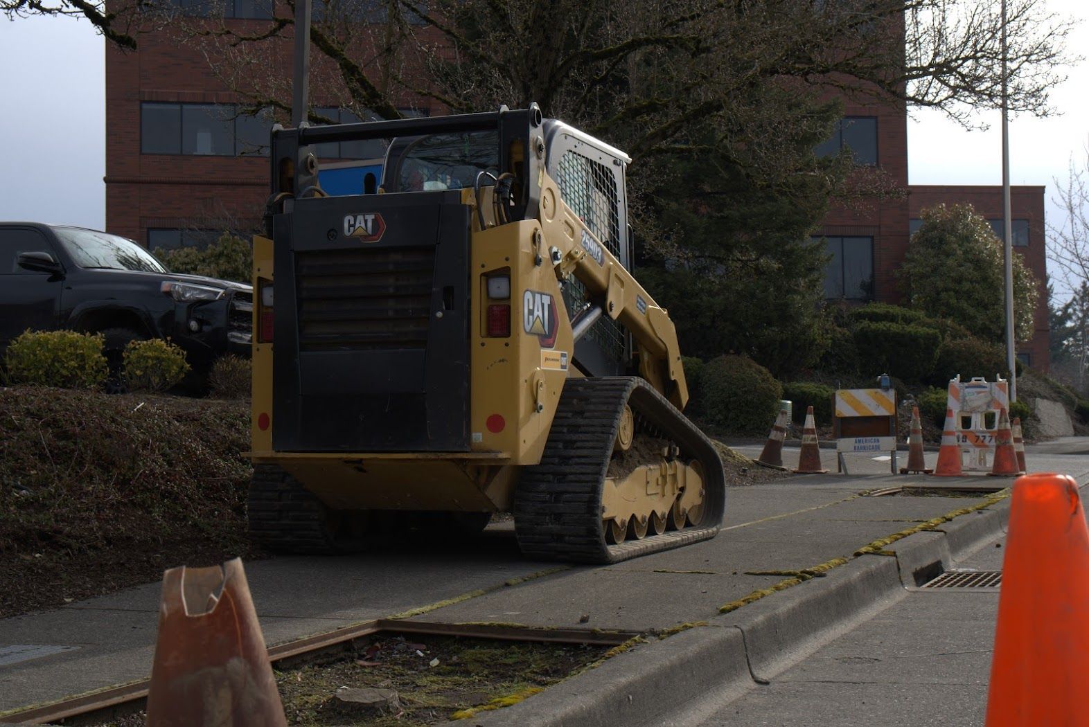 A cat bulldozer is parked on the side of the road