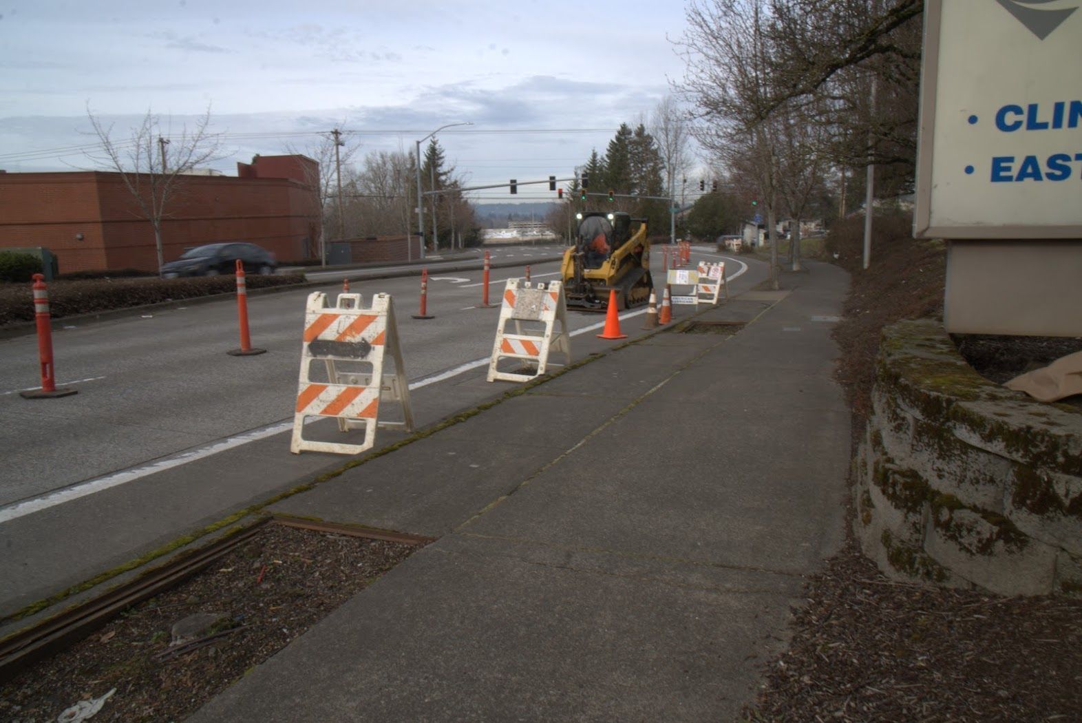 A row of orange and white traffic barriers on the side of a road.