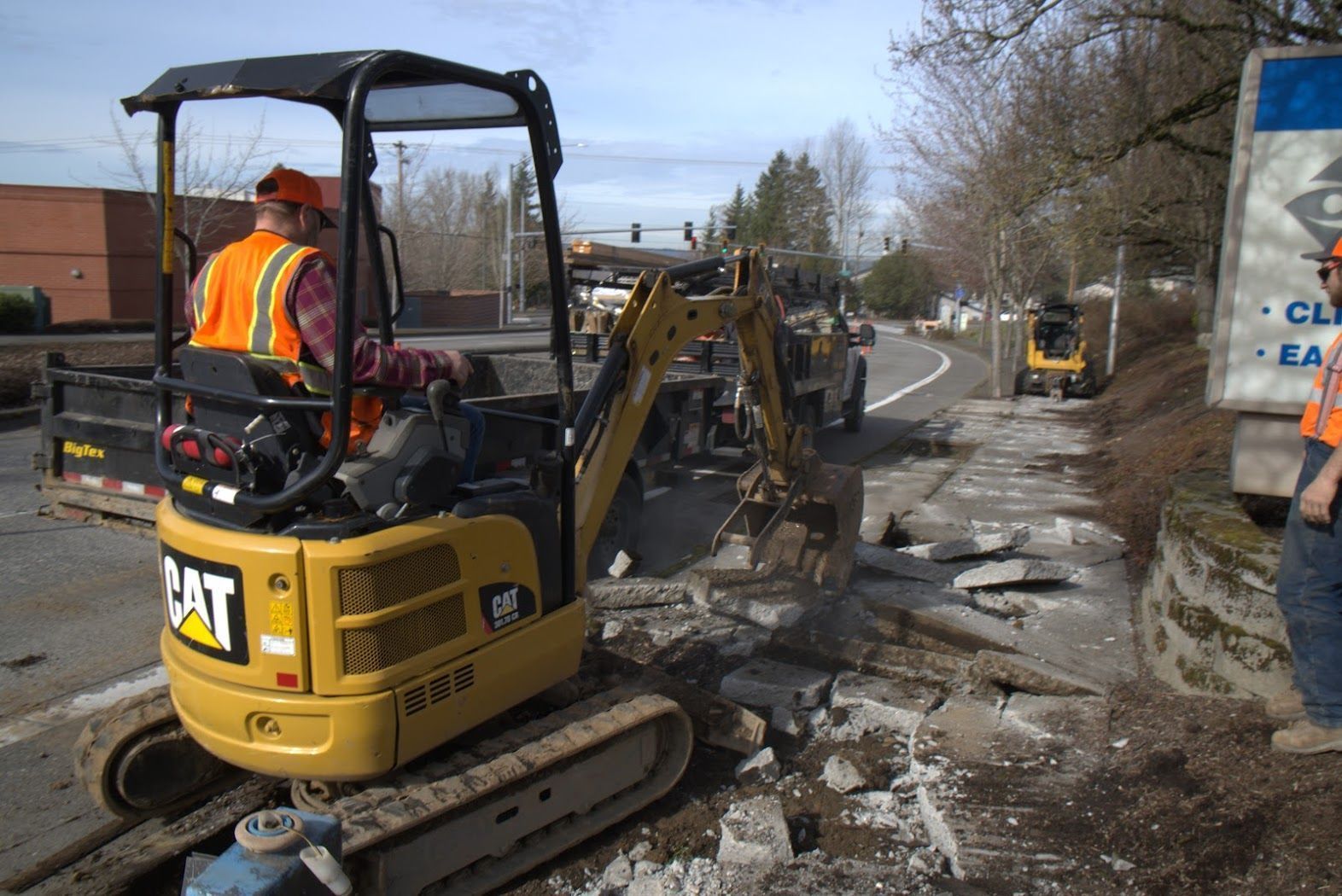 A cat excavator is being used to dig a hole in the ground