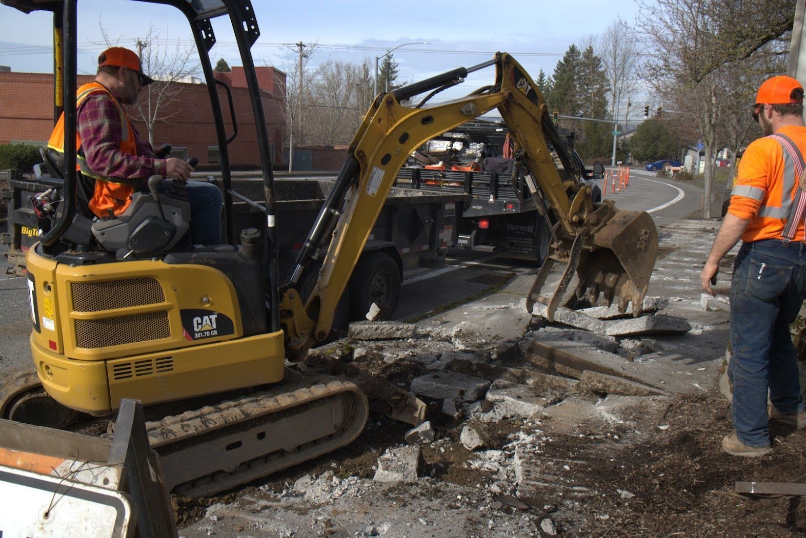 A man is driving a yellow excavator on a construction site.