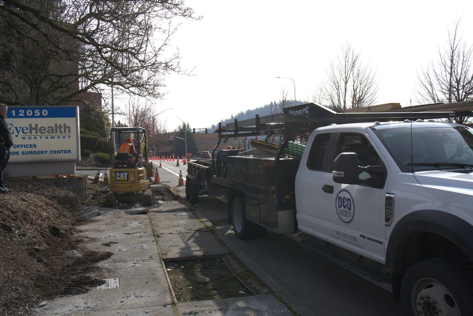 A white truck is parked in front of a sign that says kyc health