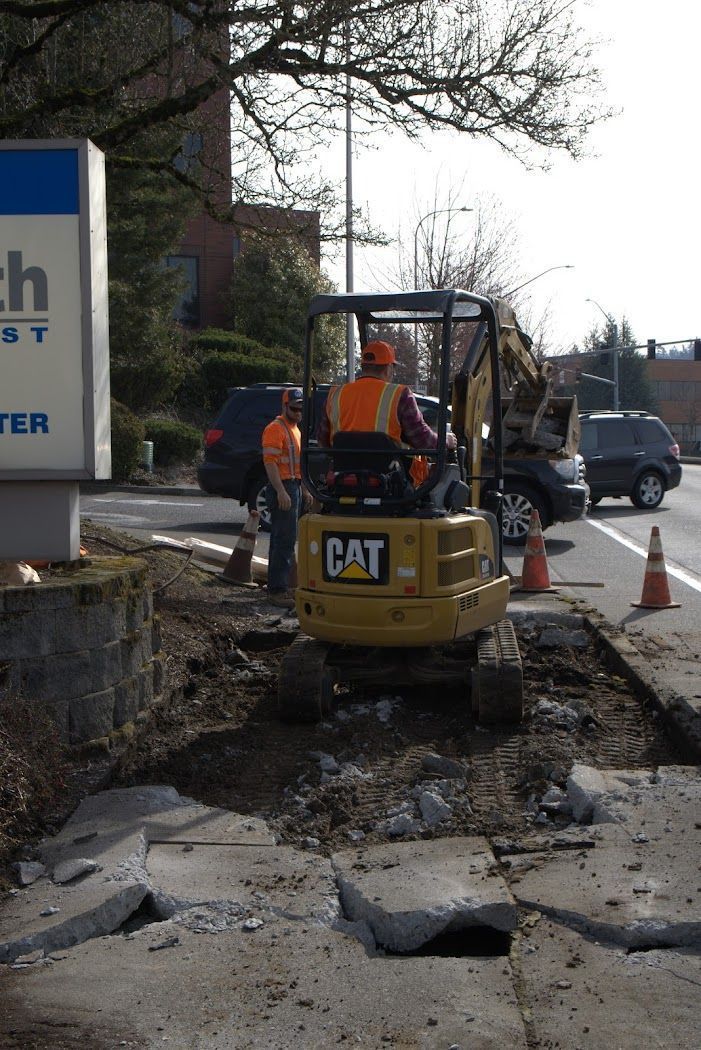 A man is driving a small yellow cat excavator