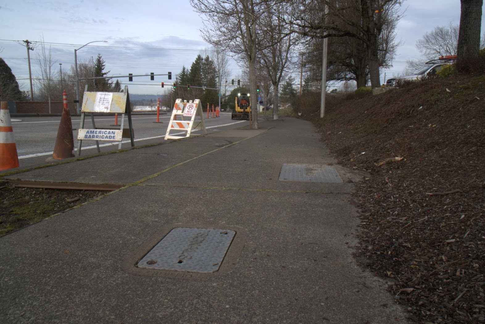 A sidewalk with a manhole cover in the middle of it