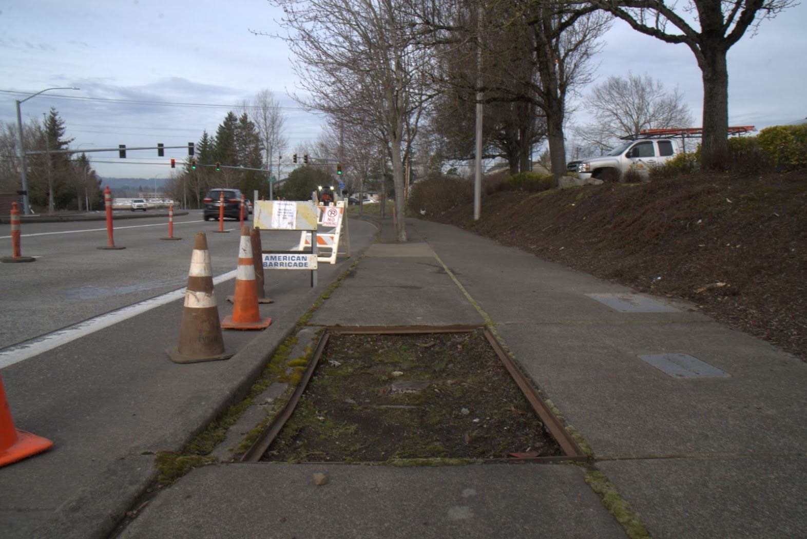 A sidewalk with a manhole cover in the middle of it