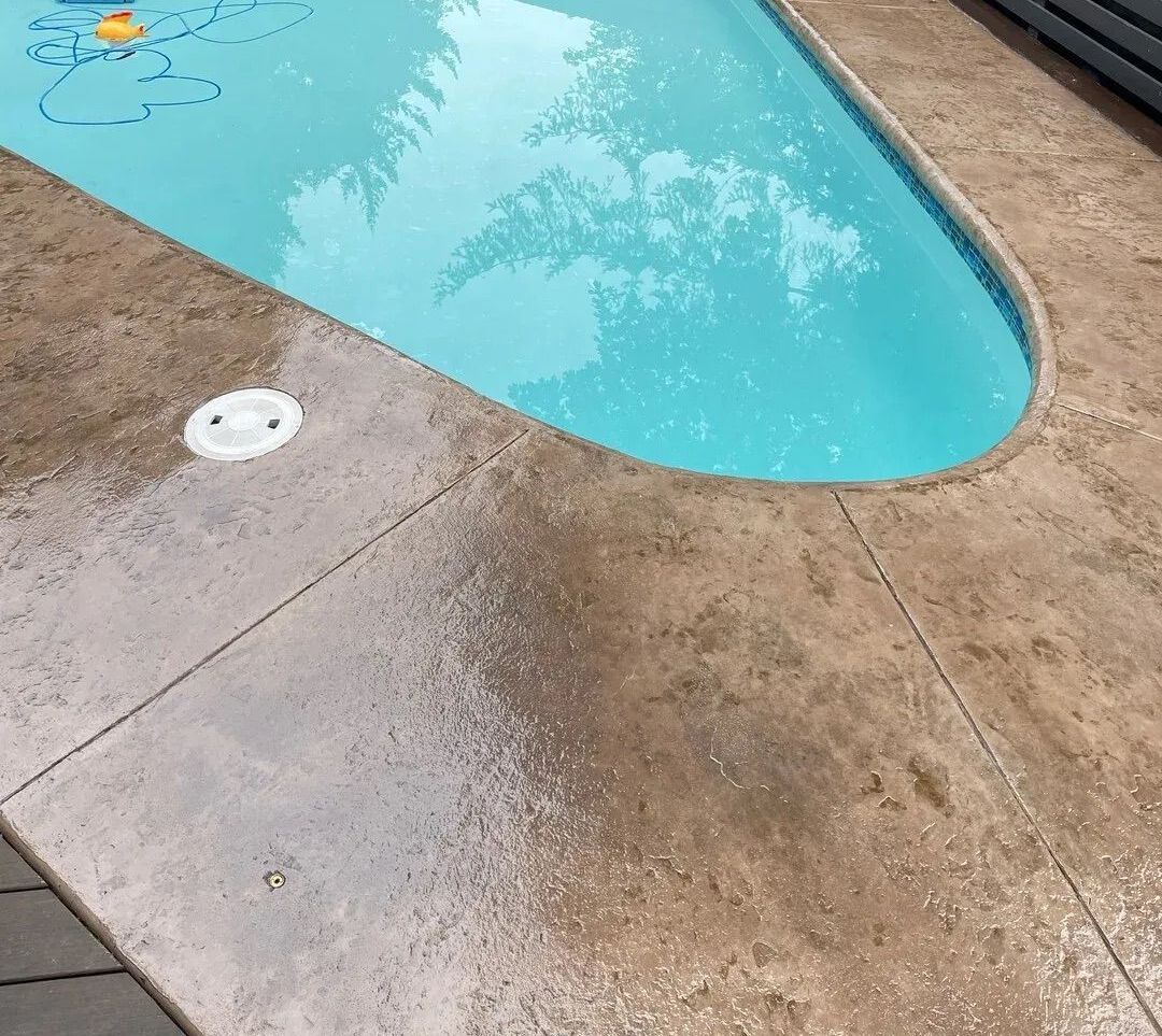 A swimming pool is surrounded by a concrete deck