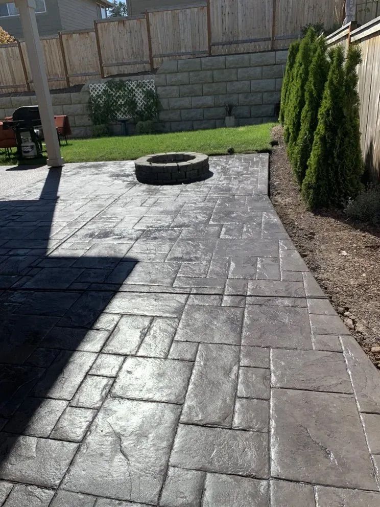 A patio with a fire pit in the middle of it.