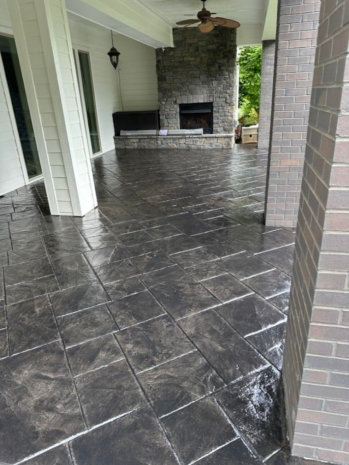A patio with a fireplace and a ceiling fan.