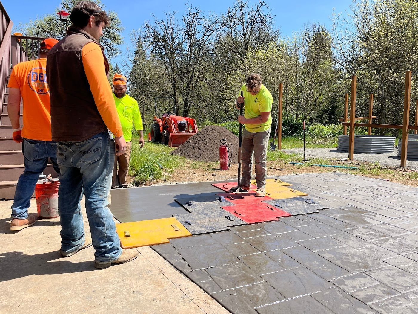 A group of men are working on a concrete driveway