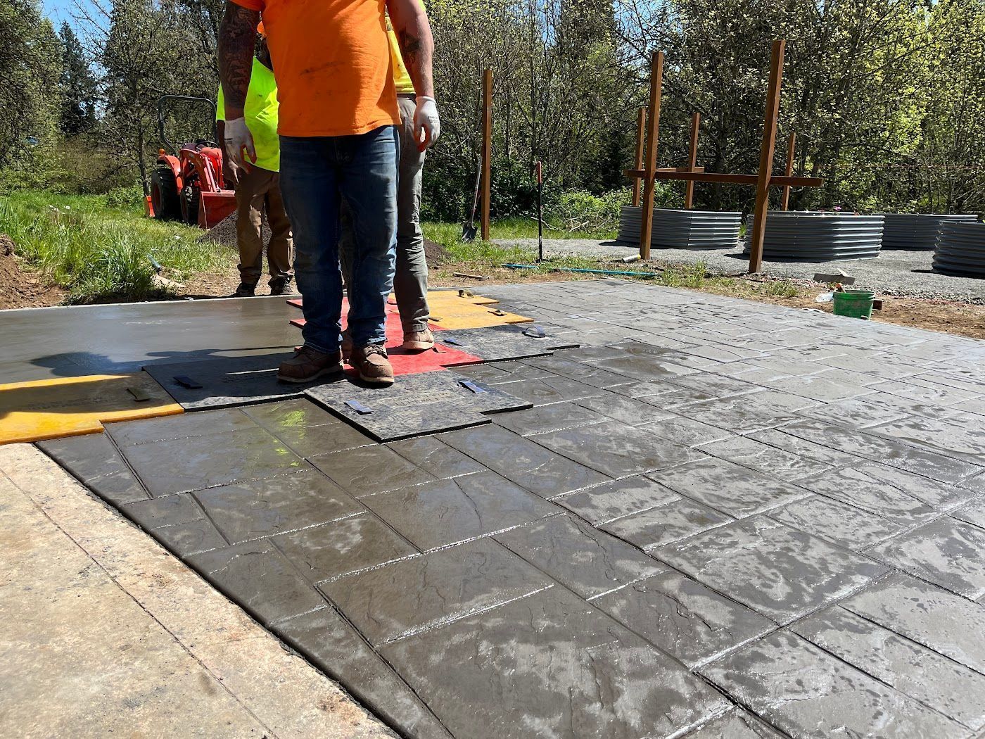 A man in an orange shirt is standing on a concrete surface.