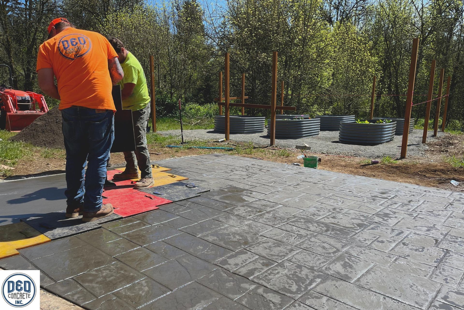 A group of men are working on a concrete driveway.