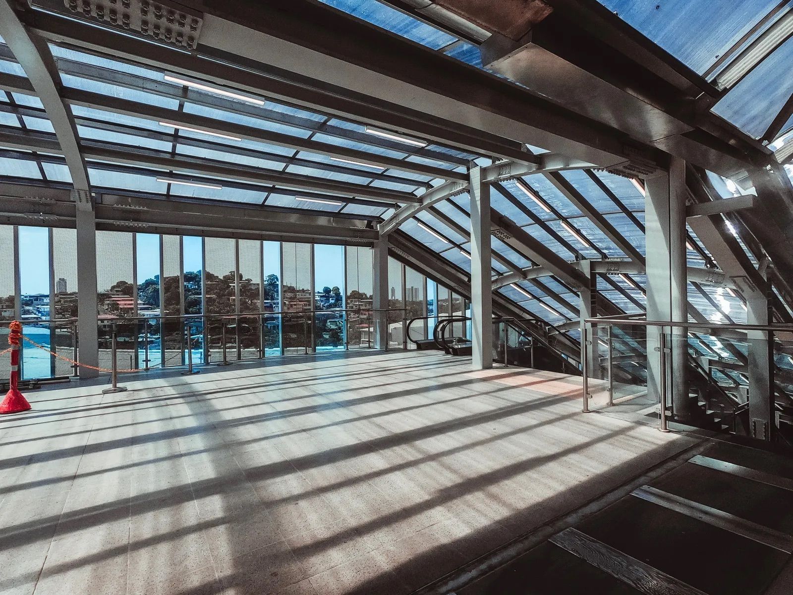 A large empty room with stairs and a glass roof.