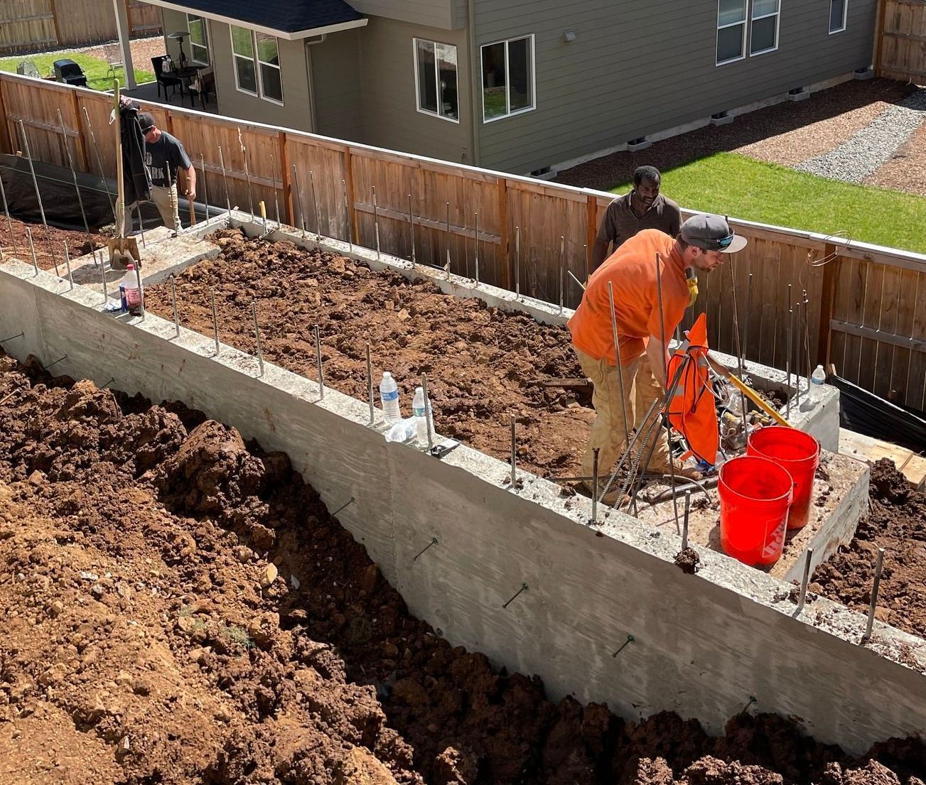 A group of men are working on a concrete wall.
