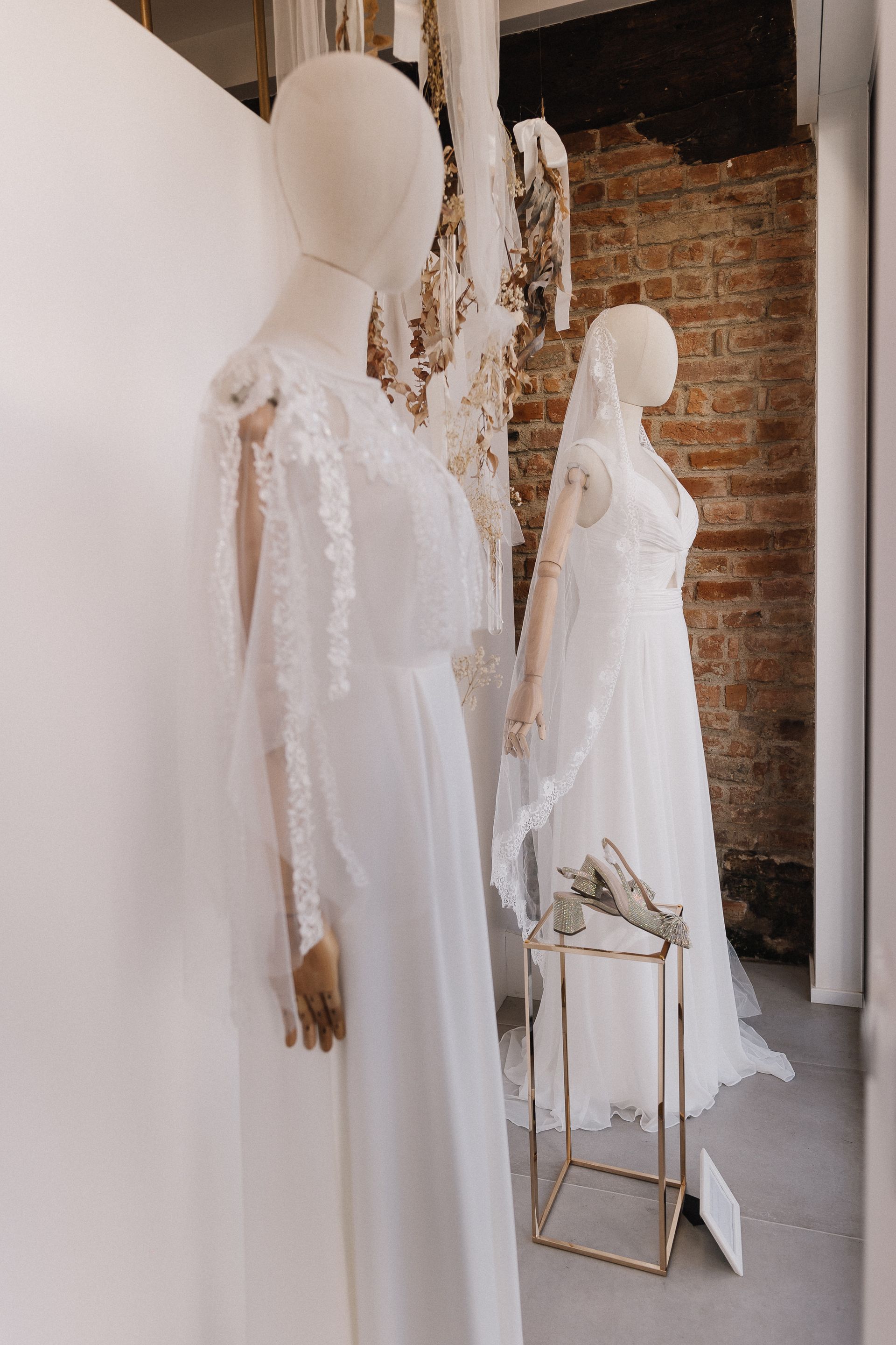 Una donna sta riparando un abito da sposa in un negozio.