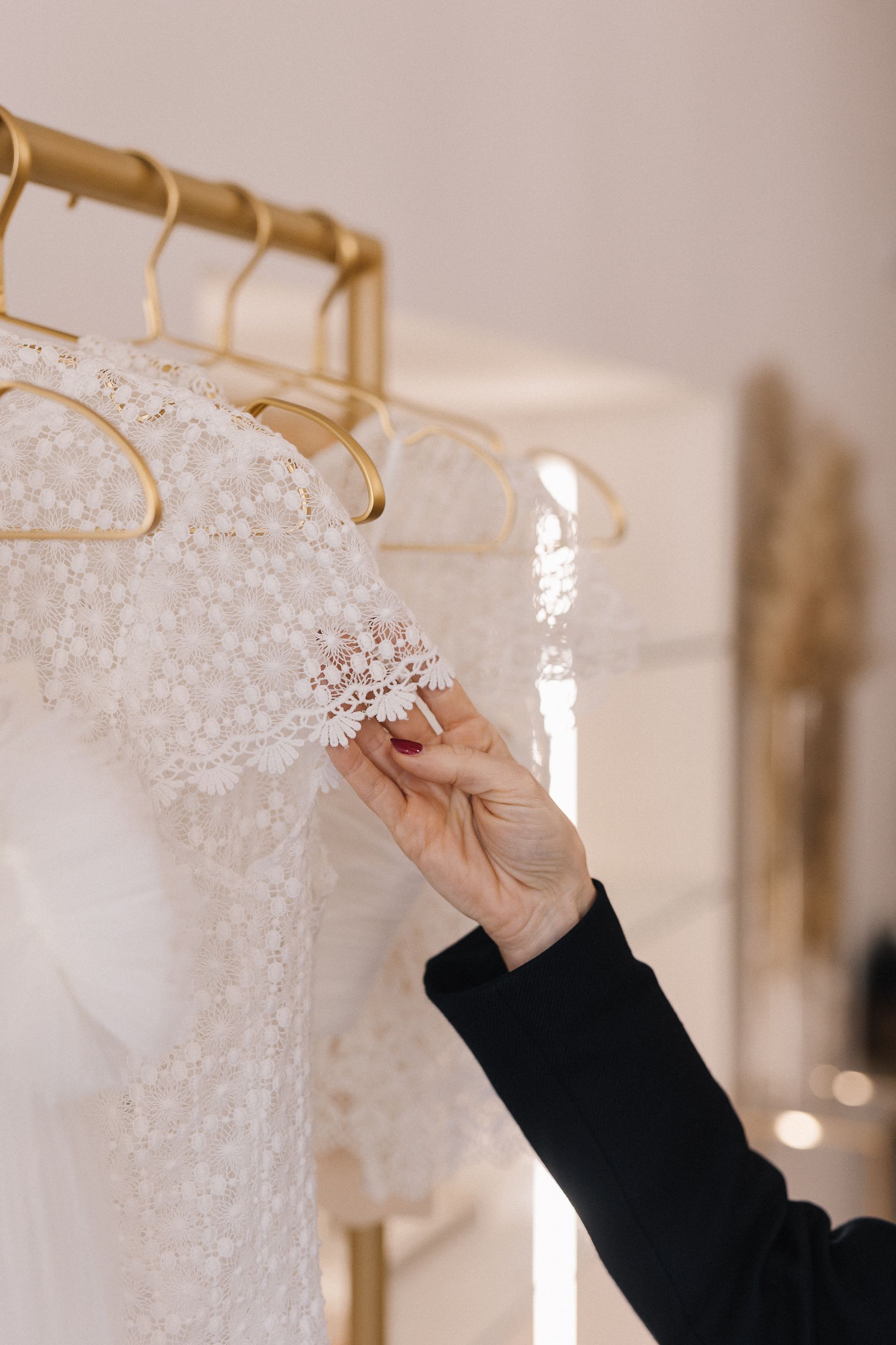 Una donna sta guardando un abito da sposa in un negozio.