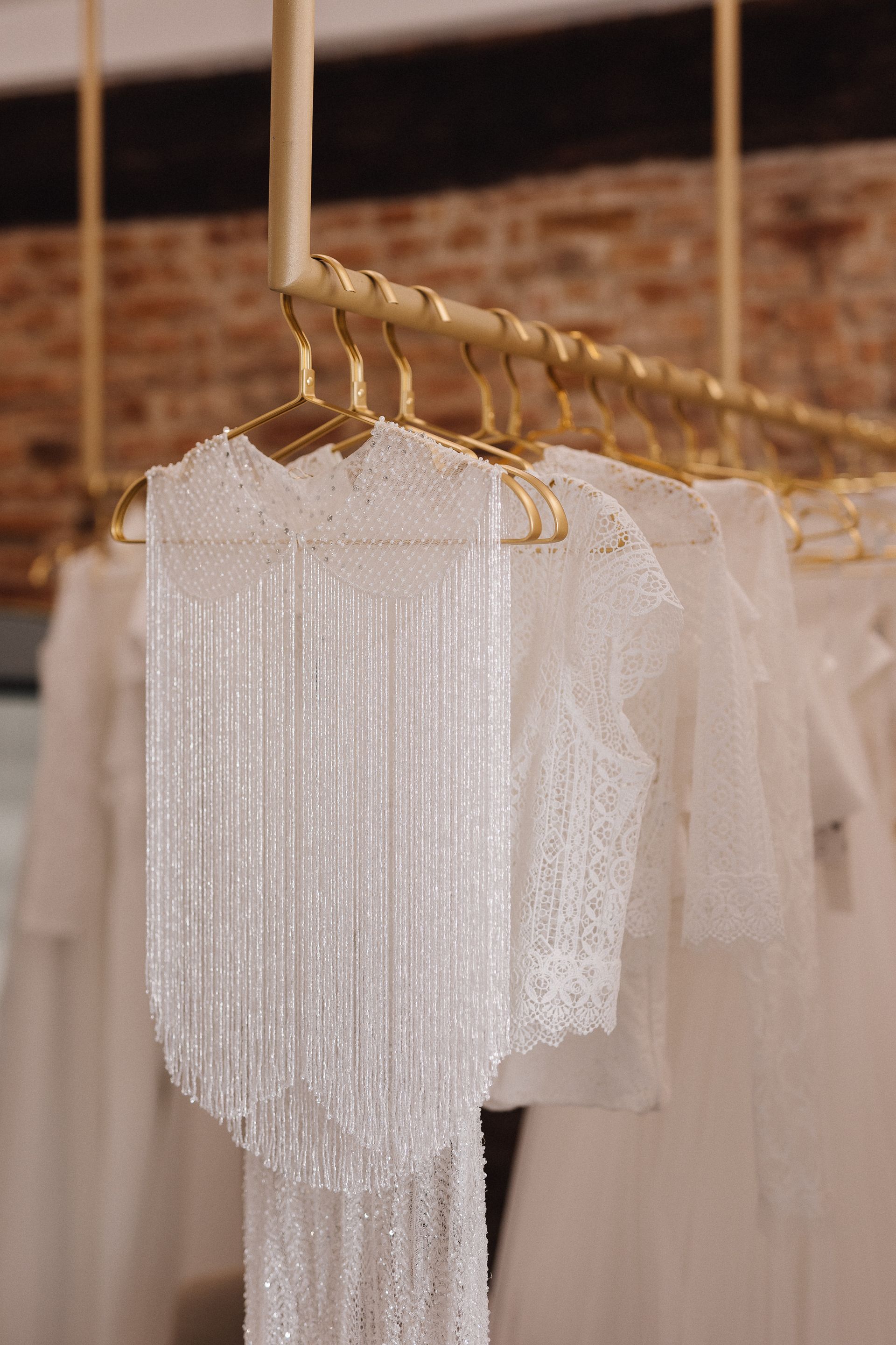 Una fila di abiti bianchi appesi su uno scaffale in un negozio.