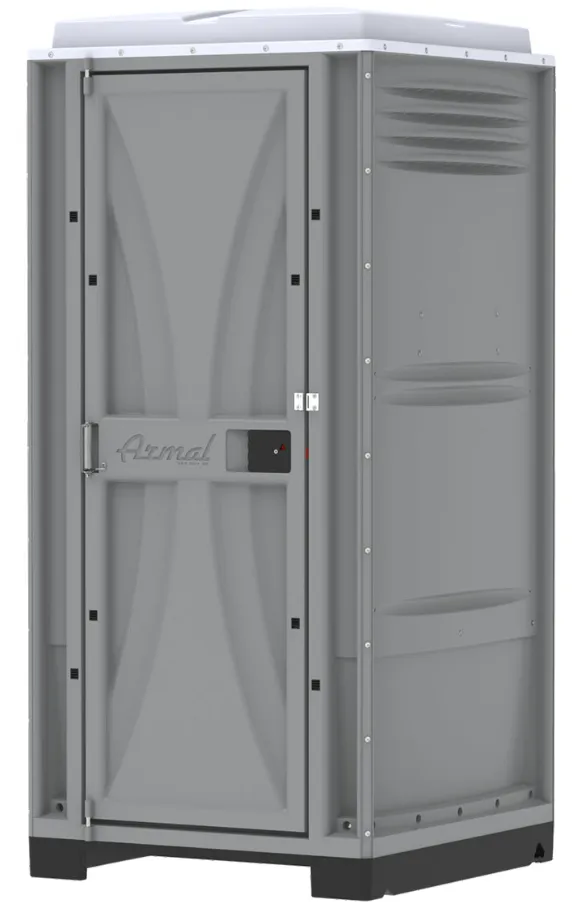 Gray portable toilet with a door in a construction setting.