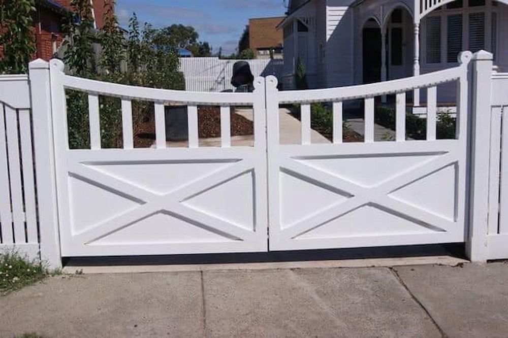 A White Wooden Gate is Open to a Driveway in Front of a House — Southern Gate Automation in Bowral, NSW