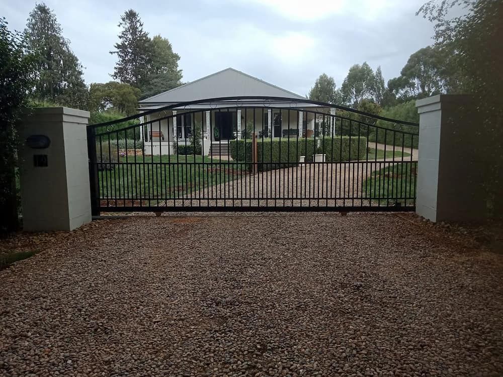 A House with a Gravel Driveway and a Metal Gate — Southern Gate Automation in Mittagong, NSW