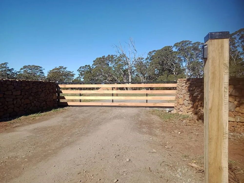 A Wooden Fence Along the Side of a Dirt Road — Southern Gate Automation in Goulburn, NSW