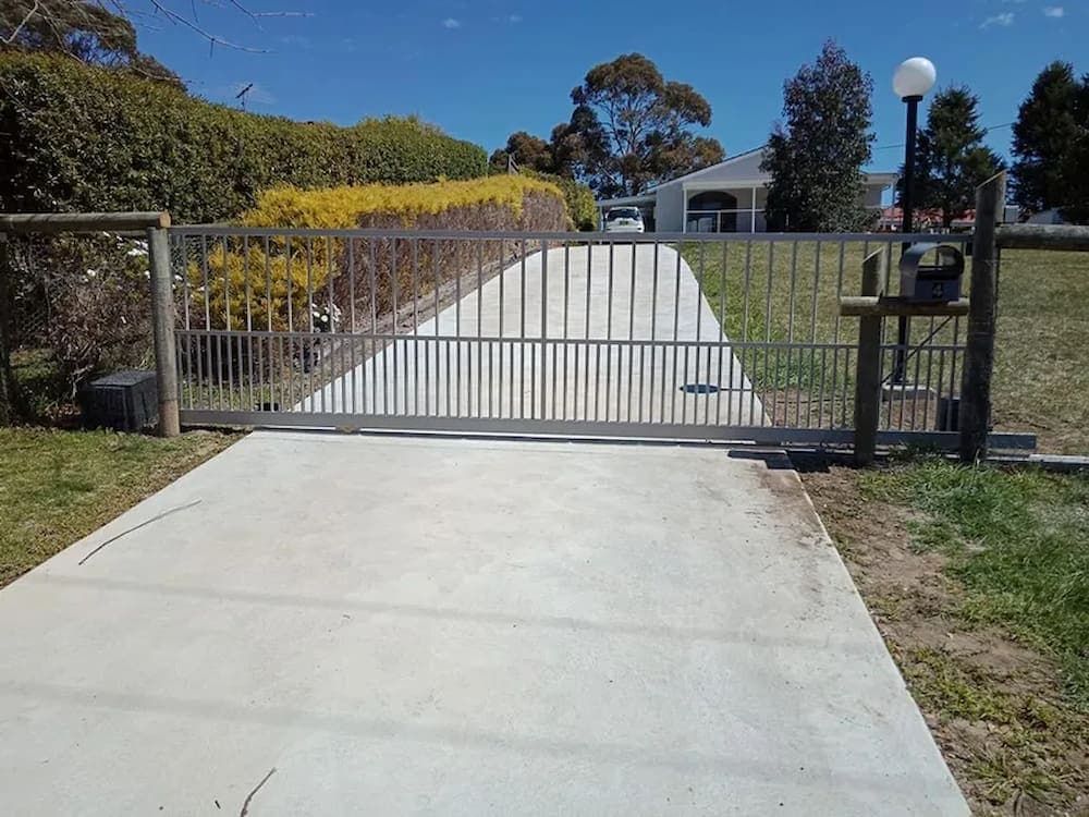 A Concrete Driveway with a Sliding Gate in the Middle of It — Southern Gate Automation in Mittagong, NSW