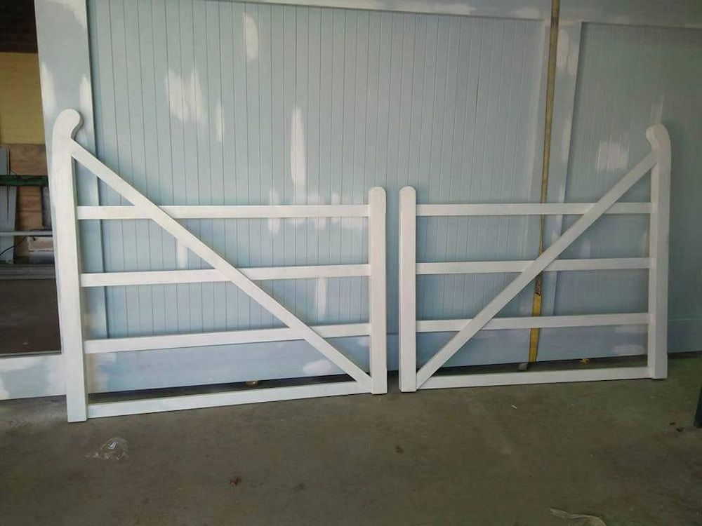 A White Gate is Sitting in Front of a Blue Wall — Southern Gate Automation in Goulburn, NSW