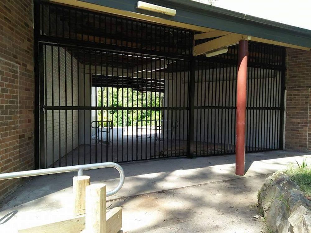 A Brick Building with a Metal Fence Surrounding It — Southern Gate Automation in Bowral, NSW