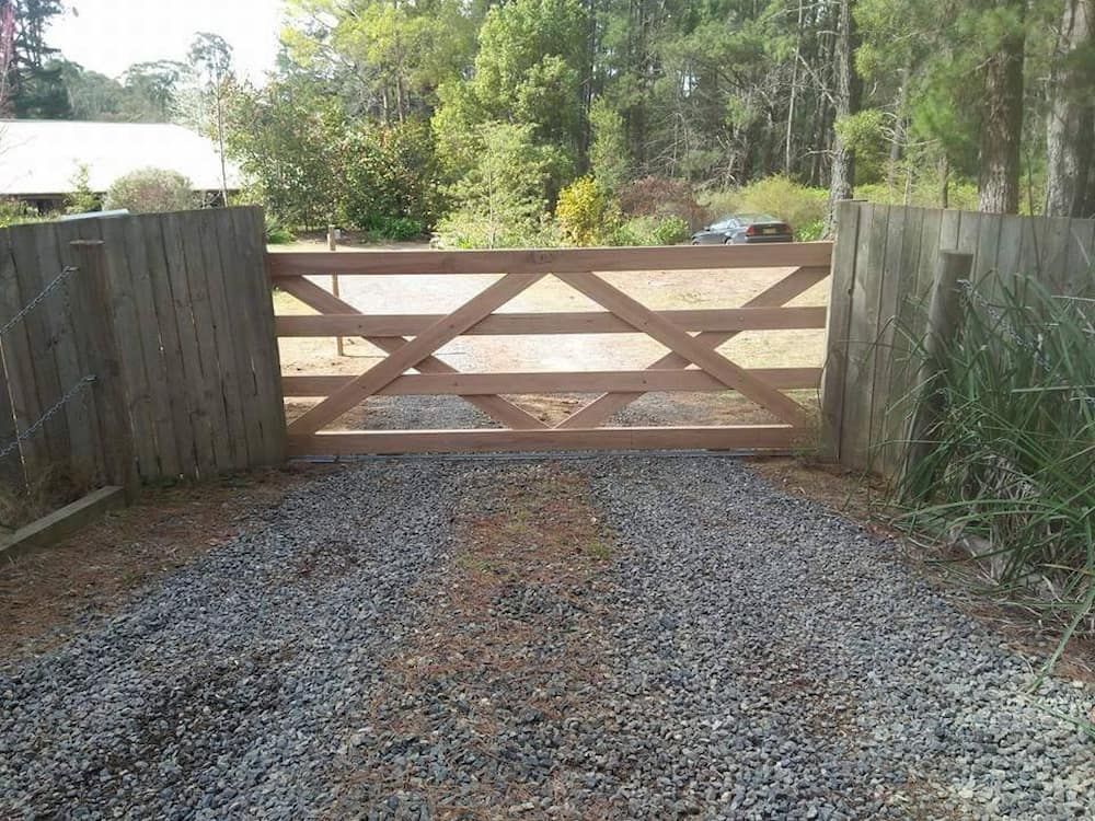 A Wooden Gate is in the Middle of a Gravel Road — Southern Gate Automation in Mittagong, NSW