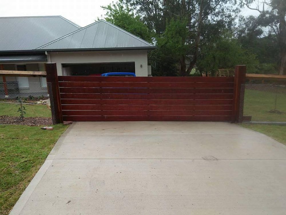 A Wooden Gate is Closed in Front of a House — Southern Gate Automation in Picton, NSW