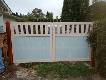 A Man is Standing in Front of a Wooden Gate — Southern Gate Automation in Mittagong, NSW