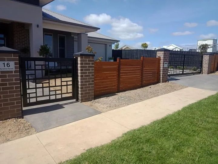 A Wooden Fence with a House — Southern Gate Automation in Mittagong, NSW