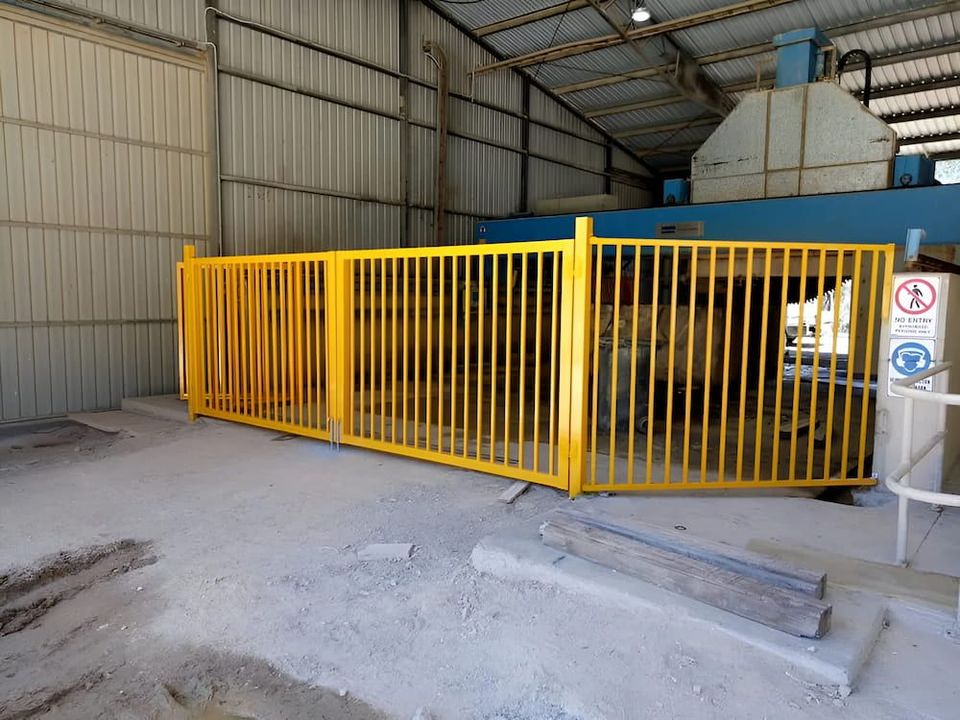 There Is A Yellow Fence In The Middle Of A Building — Southern Gate Automation in Mittagong, NSW