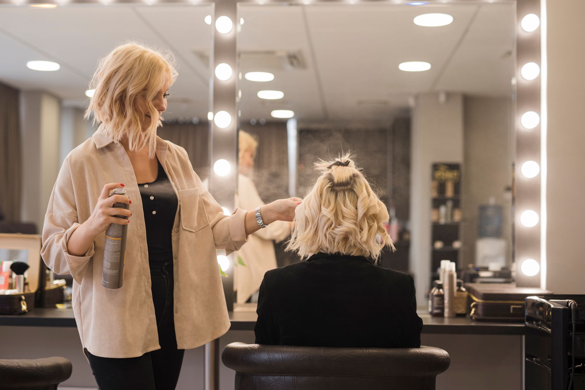A woman is getting her hair done by a hairdresser in a salon.