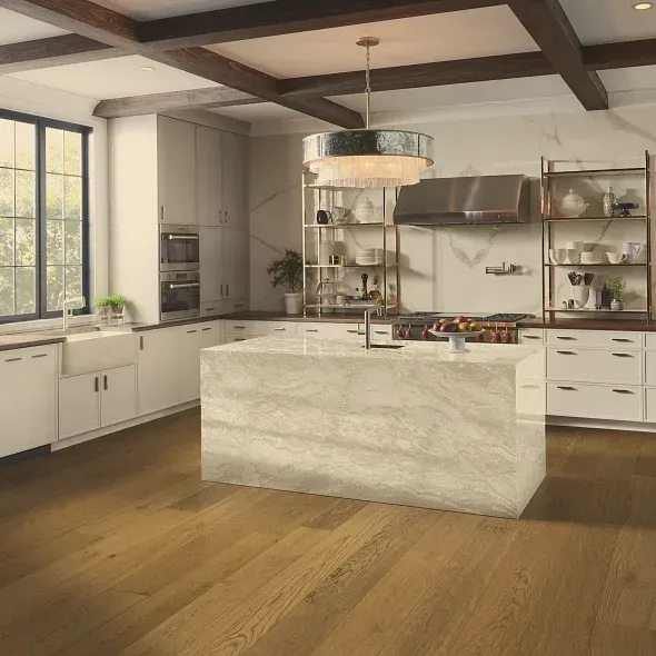 Modern kitchen with marble island, wood floor, white cabinets, and dark beams.