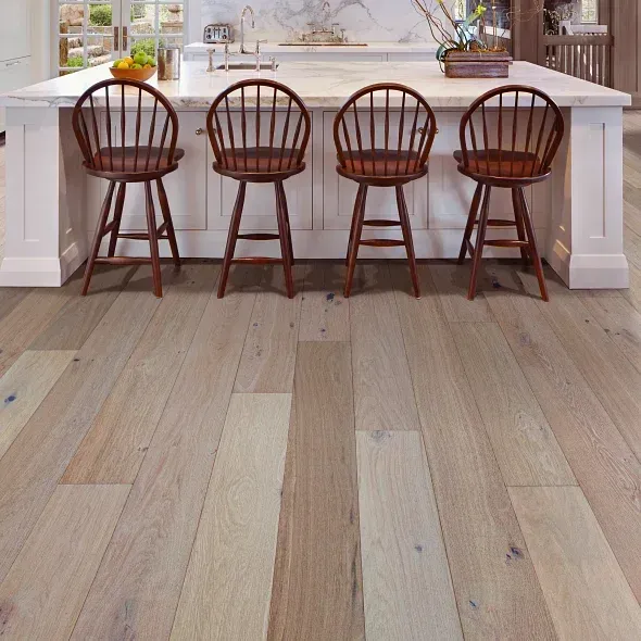 Wood flooring in a kitchen with island and four wooden stools.