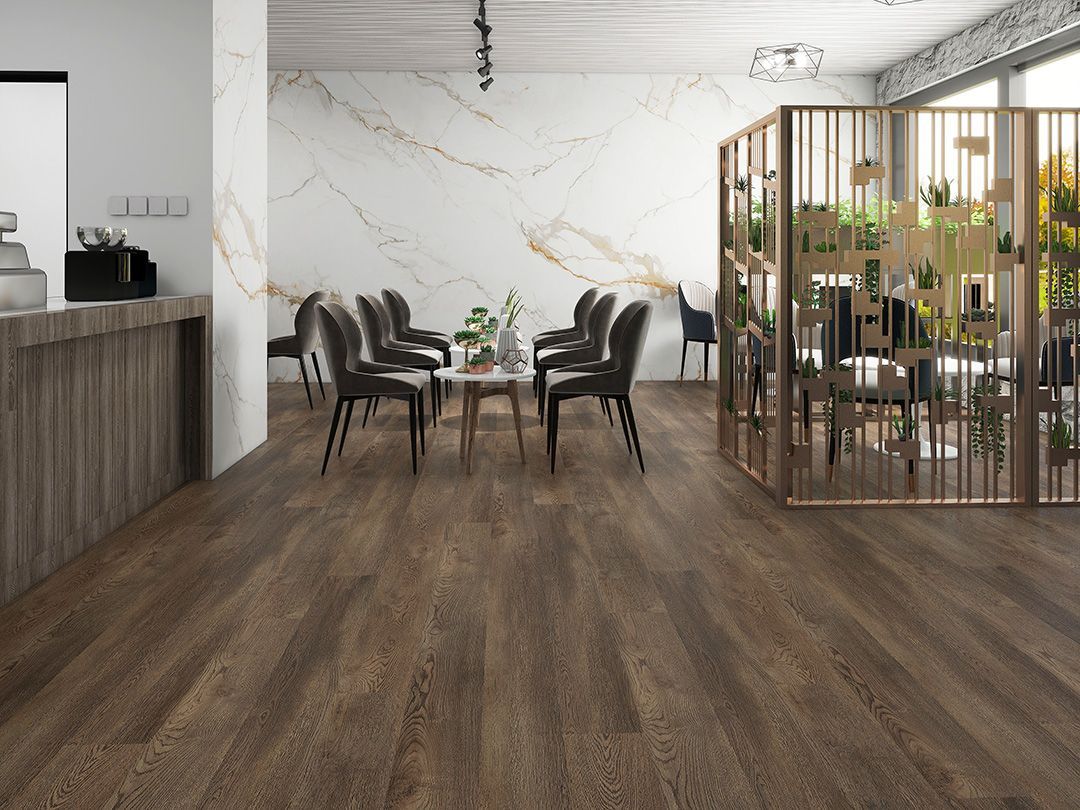 Cafe interior with dark wood floors, tables, chairs, gold accents, and decorative screens.