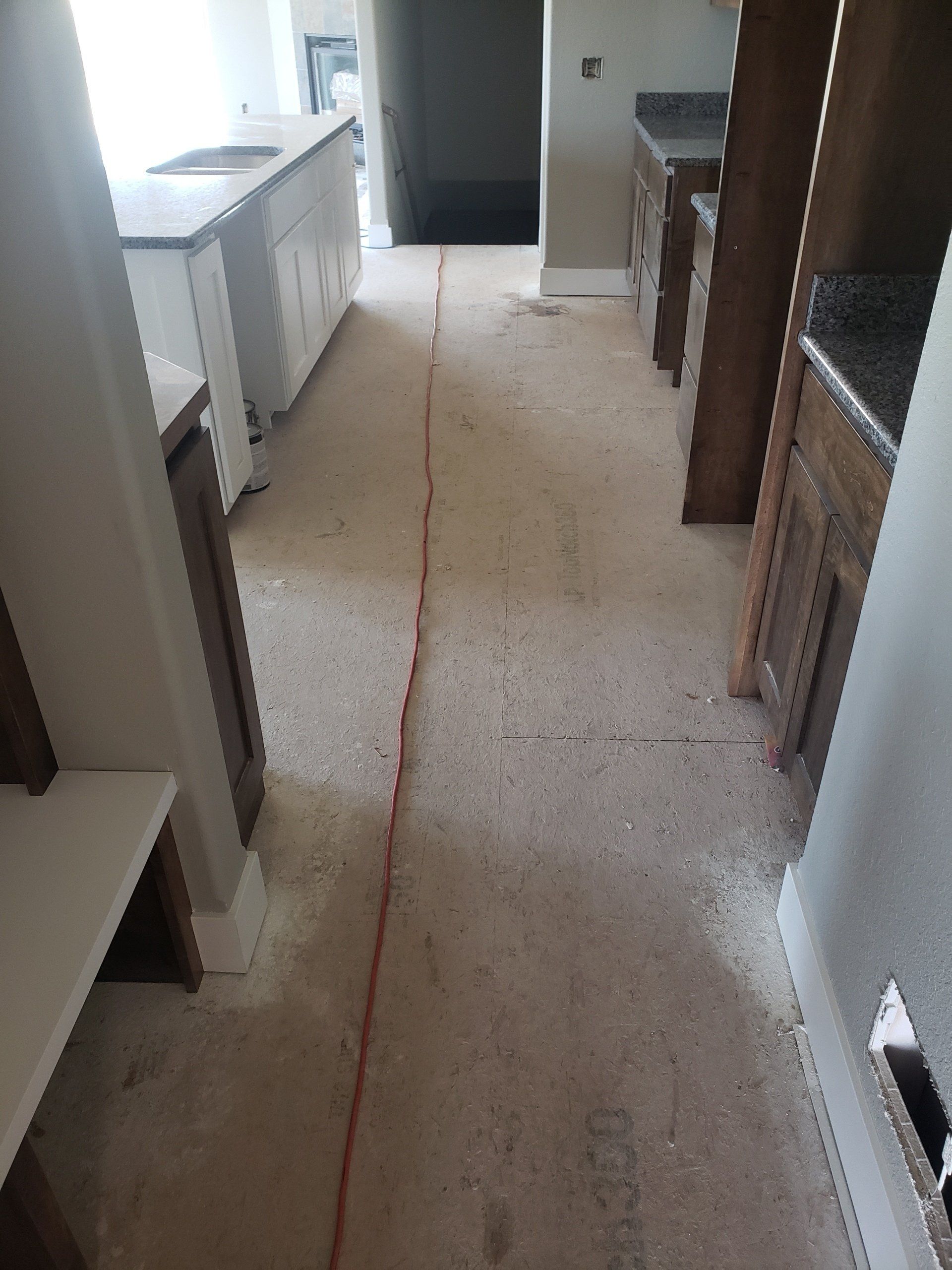 Kitchen remodel: Cabinets line the room. A red line runs down the center of the floor.