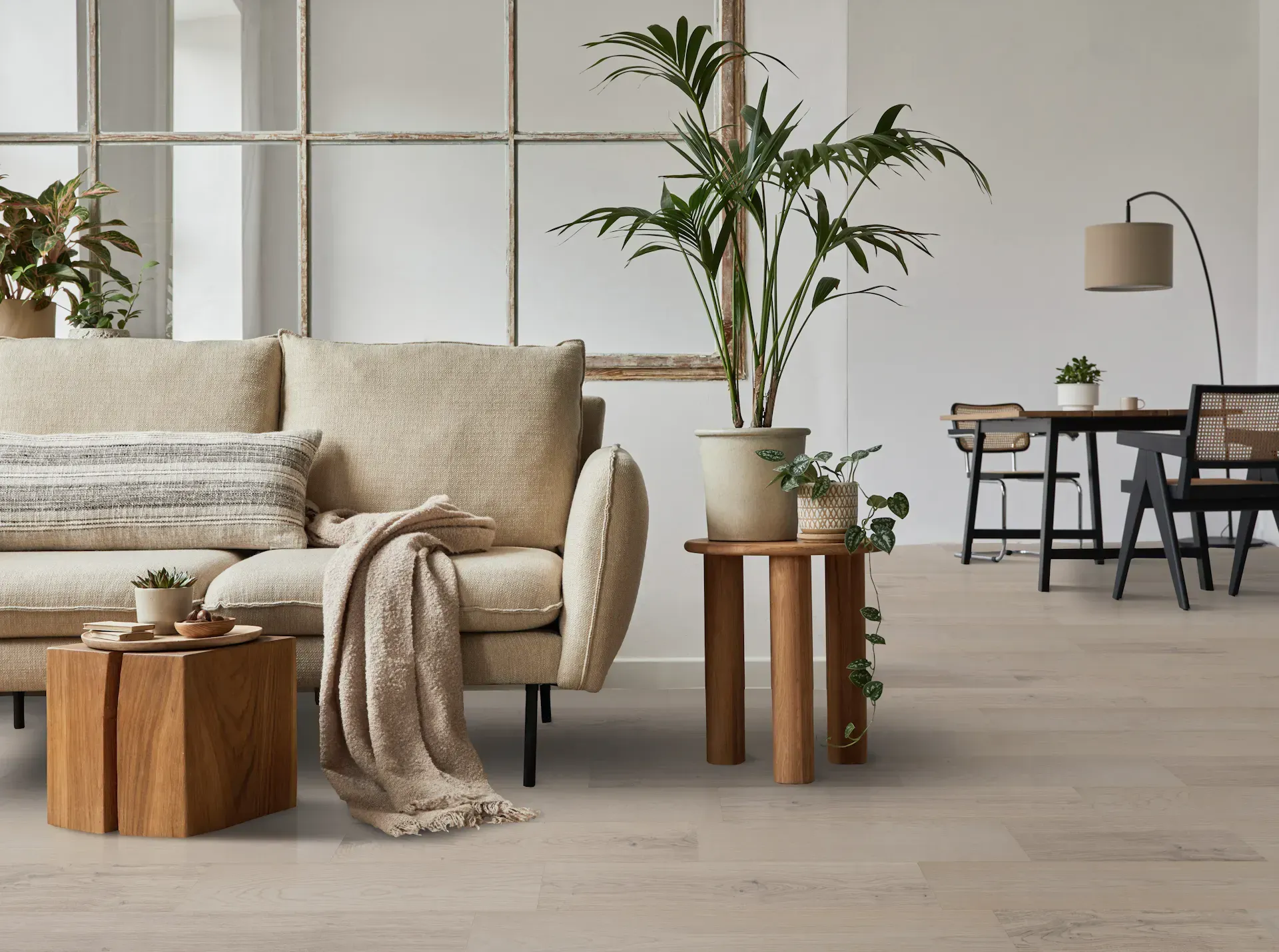 Cozy living room with beige sofa, wooden accents, and plants, offering a serene, neutral-toned ambiance.