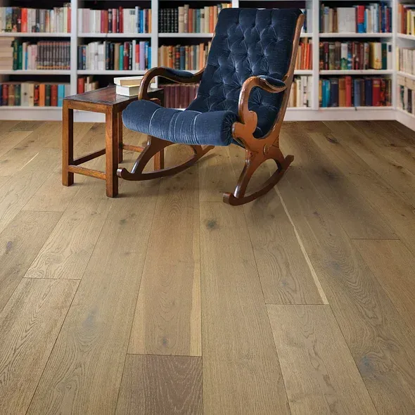 Wooden floor with rocking chair, small table, and bookshelves.