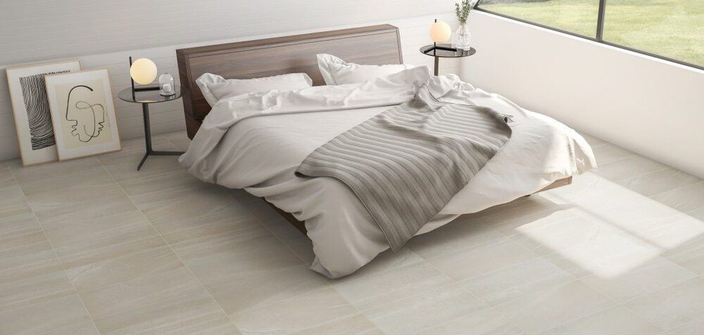 Bedroom with neutral tones and a large bed with soft bedding and a window.