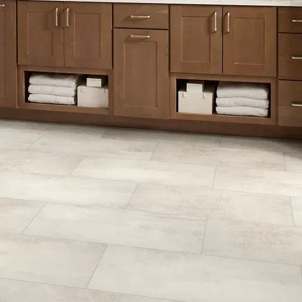 A bathroom with wooden cabinets and a white tile floor.