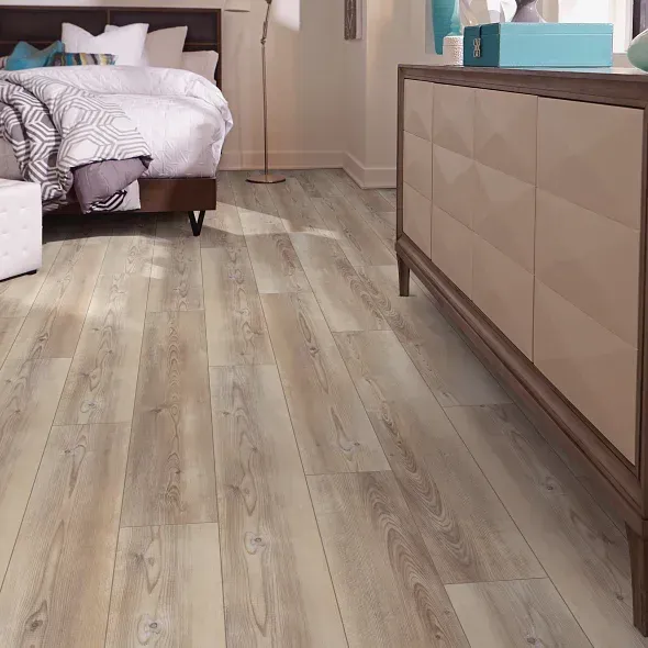Bedroom with light wood-look flooring, bed, and dresser; neutral color scheme.