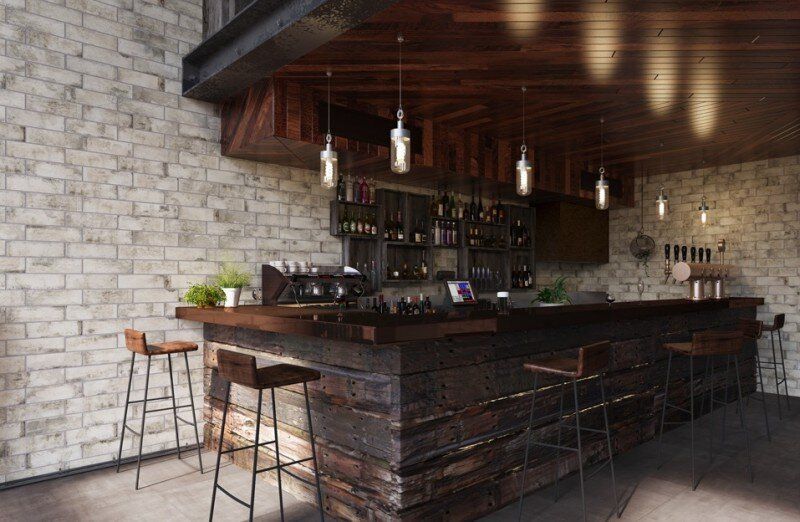 Rustic bar with brick walls, wooden counter and stools, pendant lights, and bottles of alcohol.