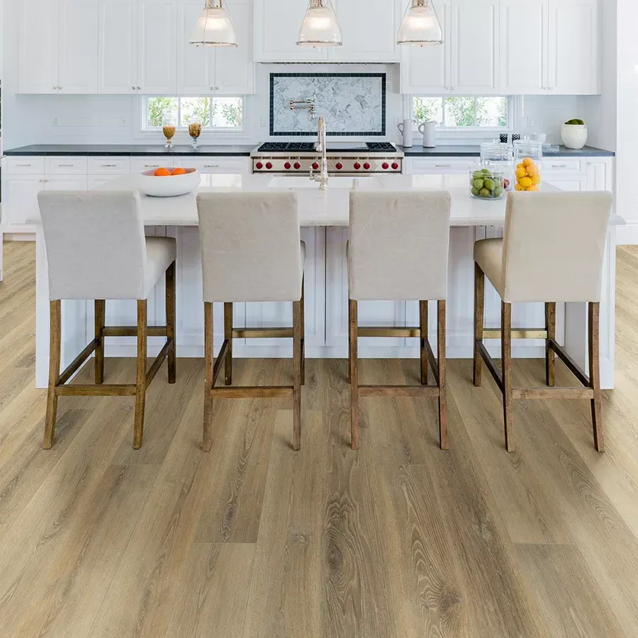 Kitchen with a white island, stools, and wood-look flooring. White cabinets and countertops.