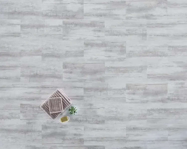 Towels, soap, and plant on gray wood-look flooring.