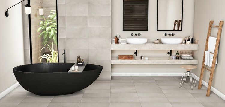 Modern bathroom with black oval tub, double sinks, and wooden towel ladder.