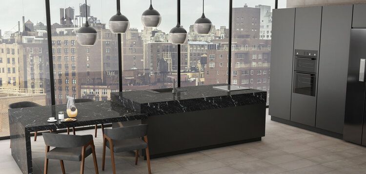 Modern kitchen with a black island and cabinets, city view through windows.