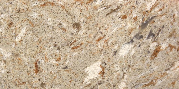 A speckled quartz countertop with tan, orange and white veining.
