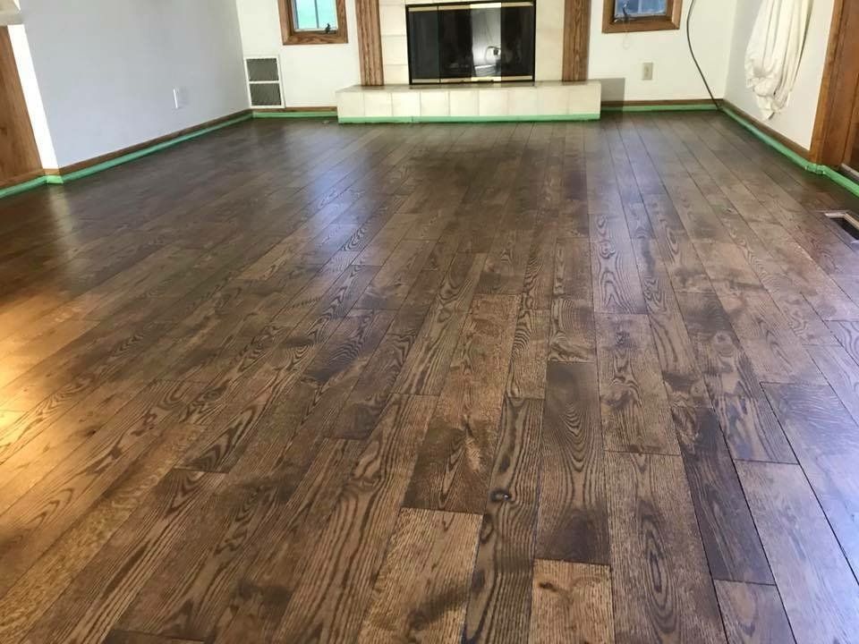 Newly refinished hardwood floor, medium brown color, in a living room.