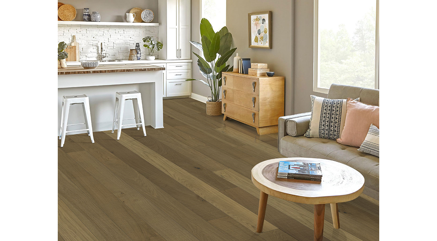 Living room with wood flooring and a small, round table, next to a couch.