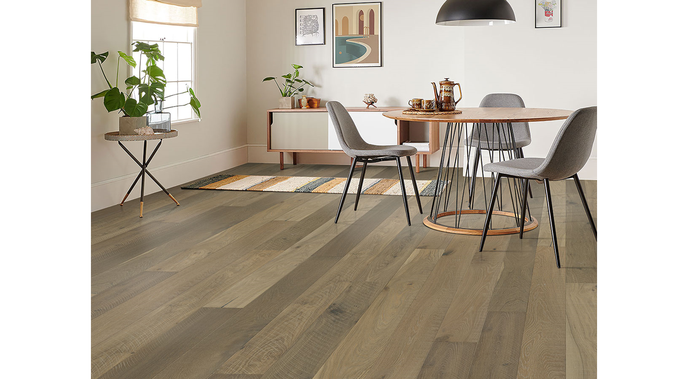 Hardwood floor in a dining room with table, chairs, and rug. Neutral colors and natural light.
